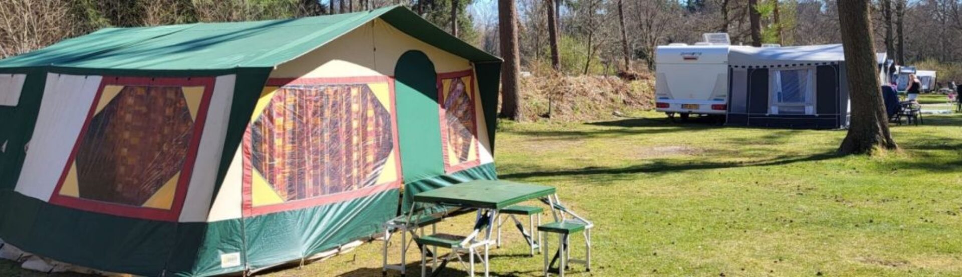 Vouwwagen op camping groen gras zon schijnt